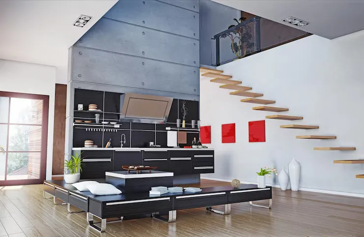 Modern open-concept living space featuring a sleek black kitchen, wooden staircase, and minimalist decor with vibrant red accents Modern open-concept living space featuring a sleek black kitchen, wooden staircase, and minimalist decor with vibrant red accents